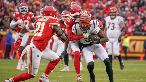 Dec 31, 2023; Kansas City, Missouri, USA; Cincinnati Bengals wide receiver Tee Higgins (5) runs the football as Kansas City Chiefs cornerback Jaylen Watson (35) makes the tackle during the first half at GEHA Field at Arrowhead Stadium. Mandatory Credit: Denny Medley-USA TODAY Sports  